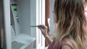Girl inserts a card into an ATM machine