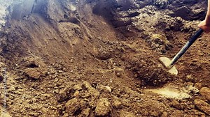 Digging soil with shovel. Worker digs the ground with a shovel. Digging soil in the garden. Shovel Digs a Underground Hole with a Shovel at the construction site.