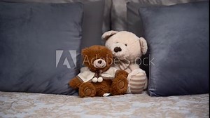 Luxury bedroom with toys on bed. Teddy Bears on the double, grey bed. Close up view.