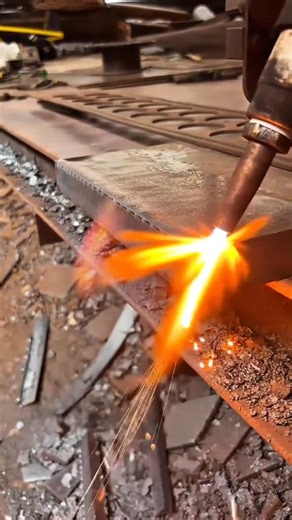 using a hot flame torch to cut through a thick metal plate precisely in an industrial workshop