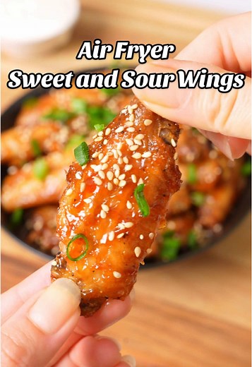 Air Fryer Sweet and Sour Chicken Wings Ingredients: 2 lb chicken wings 2 tbsp baking powder 1 tsp salt 1 tsp black pepper 1 tsp paprika Sweet and Sour Sauce: 1/4 cup brown sugar 1/4 cup apple cider vinegar 1/4 cup pineapple juice 1/4 cup ketchup 1 tbsp soy sauce 1 tbsp cornstarch 1 tbsp water Garnish: green onions and sesame seeds Instructions: 1. Start by patting the chicken wings dry with a paper towel. Mix the chicken wings with baking powder, salt, black pepper, and paprika, until the wings