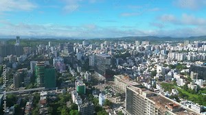 aerial drone panning shot flying over skyscrapers and small buildings crossing Gurgaon, birds eye view drone flyover, Express highway drone night view, India city drone 4k shot, IT park pune