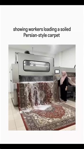 santy on Instagram: "The X post features a 12-second video of an automated industrial rug washing machine, showing workers loading a soiled Persian-style carpet, running it through a soapy rinse cycle with visible suds and water ejection, and unloading a freshly cleaned version. Viewer replies split on whether the footage is AI-generated, citing discrepancies like shifting carpet patterns and vanishing water puddles, though similar real machines from Euromak and Cleanvac process rugs at rates of