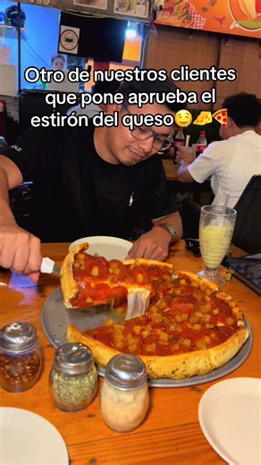 Estirar el queso de pizza en Pizza Roble, Managua