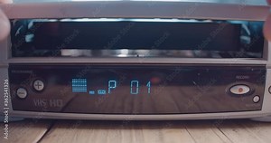 Inserting VHS video tape into retro VCR player