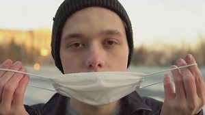 Student guy wearing a protective medical mack and looking at camera close up