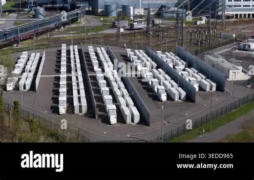 Aerial view of a large scale battery energy storage system facility for renewable power, featuring rows of containerized lithium ion units connected to the electrical grid through a substation Stock Video Footage - Alamy