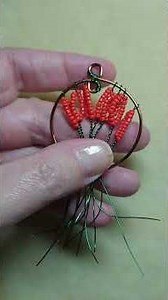 Making a tree-of-life pendant with red seed beads on green wire
