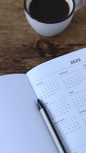 2025 new year calendar in notebook with cup of coffee and holy bible book. Vertical video.