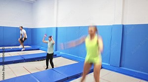 Indoor trampolines for adult people, positive young men and woman training in sports center