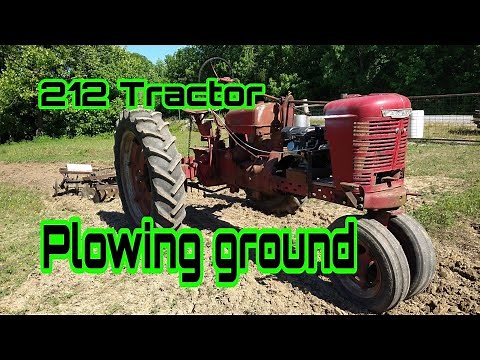 Predator 212 Tractor plowing ground. 6.5 horsepower full size tractor pulling a disc.