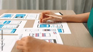 Panorama video of startup UX developer or company employee design user interface or UI prototype for mobile application or website software with software display on smartphone in office. Synergic