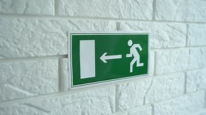 Exit emergency sign in 4K slow motion. An exit sign hangs on a wall. 4k stock footage.