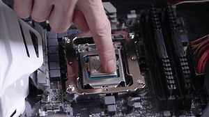 Close-up high-angle view of unrecognizable technician man applying and smearing new thermal paste to PC CPU processor chip. Concept of computer hardware, repairing, upgrade and technology.