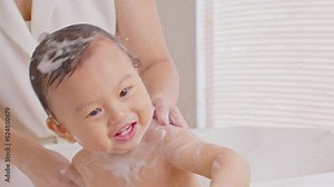 Close up asian newborn baby bathing in bathtub. mother bathing her son in warm water. Happy adorable newborn infant smile in tub relax and comfortable good moment with mom. Newborn baby care concept Stock Video