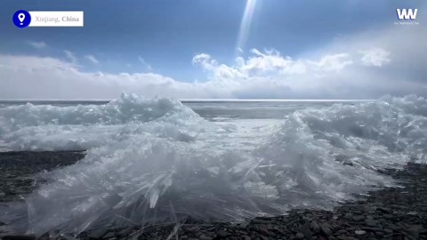 Mesmerizing crystalline ice sheets shatter as they push onto shore in China
