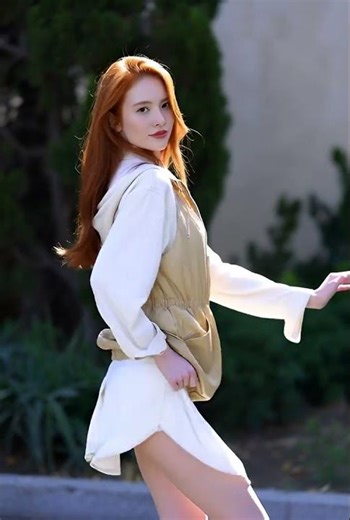 A stunning red-haired girl dances with effortless grace