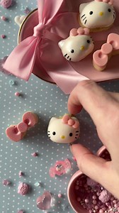Hello Kitty Cookie Bites 🎀 Bake sugar cookies in the silicone mold at 350F for 15 mins on a sheet pan. Once cool remove cookies from mold. Melt yellow meltables and fill in the nose. Melt light pink meltables and fill in the bow. Once both are completely set add the white meltables on top and place the cookie inside. Place in freezer for 5 mins for quicker setting time. Melt black meltables and fill in the eyes and use an edible black marker to line the whiskers. Spray with silver edible sparkl