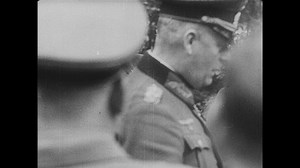 1940s Germany: Wilhelm Keitel walking with officer. Officer gives pen to Keitel, drops pen. Keitel signs armistice.