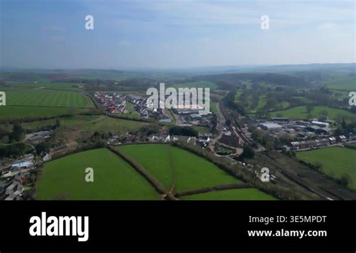 Crediton, Devon, England: DRONE VIEWS: The drone flies south east towards Crediton railway station, Well Park and green belt, new build houses (left). Crediton is a market town situated on the main road and railway routes from Exeter to Barnstaple Stock Video Footage - Alamy