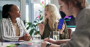 Business people, designers and meeting with phone for app, software development or innovation at office. Group of employees in team discussion for UI, interaction or engagement on mobile smartphone