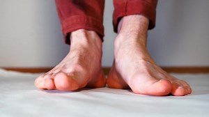 Bare feet of a man. A man takes steps and moves his fingers.