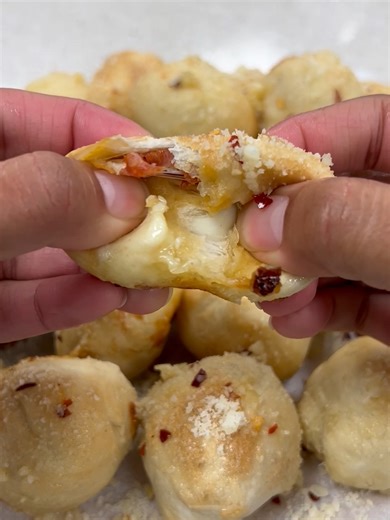 These air-fryer pizza puffs deliver all the flavor of cheesy pepperoni pizza in a bite-sized snack perfect for serving after school, at parties or on game day. Full recipe below: Ingredients 1 loaf (1 pound) frozen pizza dough, thawed 20 slices pepperoni 8 ounces part-skim mozzarella cheese, cut into 20 cubes 1/4 cup butter 2 small garlic cloves, minced Dash salt Marinara sauce, warmed Optional: Crushed red pepper flakes and grated Parmesan cheese Directions Preheat air fryer to 350°. Shape doug