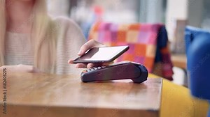 A POS terminal is placed and removed for a NFC payment in a cafe.