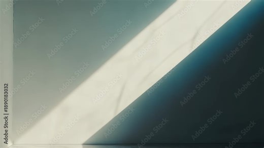 Empty room corner with a diagonal beam of natural sunlight creating a dynamic contrast between brightly lit and softly shadowed areas on plain walls and floor, conveying concepts of space and light