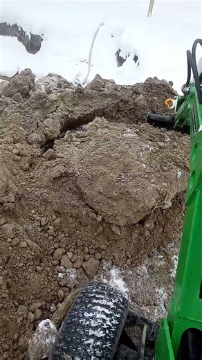 Mini excavator vs. block of frozen topsoil.
