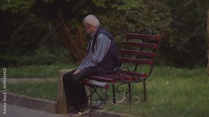 Elderly man on a park bench. Mature adult male relax on bench. Sad grandfather. Tired man.
