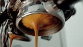 4K Pouring coffee stream from professional machine in cup. Barista...