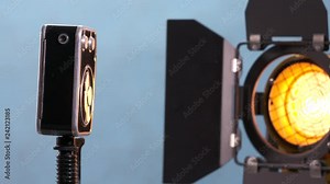 Vintage 8mm film movie camera and Fresnel light on blue background. Old Soviet Russian camera with mechanical motor rotating. Close-up Stock Video