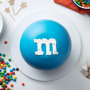 True M&M aficionados will love this embiggened M&M cake wrapped in a candy shell and stuffed with even more M&Ms. | Sugar Fix