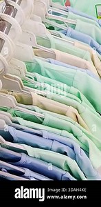 A row of pastel colored t-shirts on a hanger Stock Video Footage - Alamy