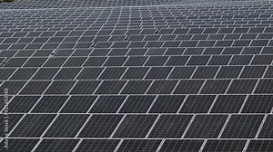A wide view of a large array of solar panels aligned to capture sunlight, representing renewable energy and sustainability in modern technology.