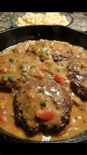 Smothered Hamburger Steak RECIPE A soul-warming Southern classic — juicy hamburger steaks pan-seared and simmered in rich onion & pepper gravy. Perfect over mashed potatoes or rice! 📝 Ingredients: For the Hamburger Steaks: 1 ½ lbs ground beef (80/20) 1 egg ¼ cup breadcrumbs 1 tsp onion powder 1 tsp garlic powder 1 tsp Worcestershire sauce Salt & pepper to taste For the Gravy: 1 tbsp oil or butter 1 small onion, sliced 1 bell pepper, chopped (optional) 2 tbsp all-purpose flour 2 cups beef broth