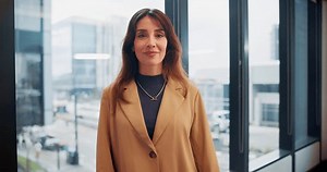 Business woman, arms crossed and face in office by window with smile, pride and confidence. Person, employee and management for career, excited and portrait in workplace at corporate insurance agency