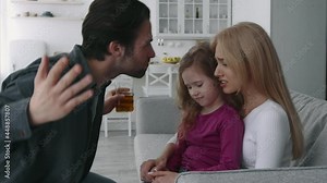 Alcohol addiction and family issues. Aggressive drunk man shouting at his crying depressed wife and daughter
