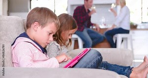 Children Use Digital Devices As Parents Drink Wine