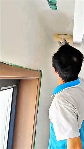 Person inspecting ceiling joint with green repair tape