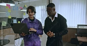 Two colleagues collaborating and brainstorming during a business meeting, using sticky notes and a laptop in a modern office setting.