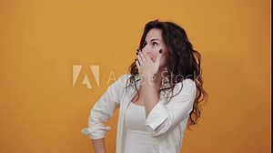 Hello arm sign, showing the five fingers, waving and greeting with hand as notices someone. Young attractive woman, dressed white blouse, with brown eyes, curly hair, yellow background
