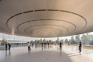 foster   partners sets world's largest carbon-fiber roof on glass cylinder for apple's theater