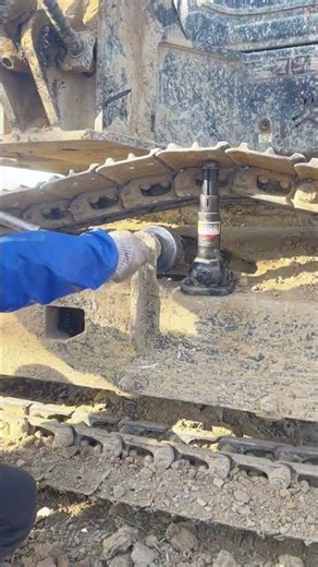 Mechanic Adjusting Track Tension on Heavy Excavator