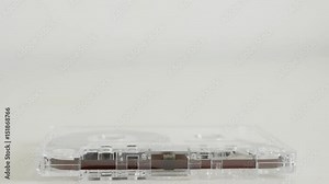 Transparent magnetic tape on white background 4K 2160p 30fps UltraHD tilting footage - Vintage analogue compact audio cassette slow tilt 3840X2160 UHD video