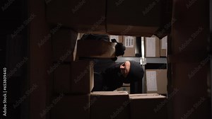 Robber or intruder inside a warehouse, police lights outside the window, security and alarm in warehouses