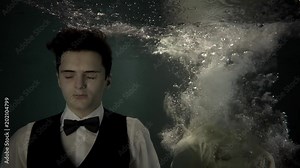 Young guy is floating underwater and dreaming. Woman in dress is plunging inside falling down, man is opening eyes