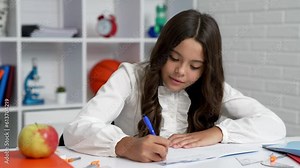 busy child writing in grammar book at lesson, knowledge