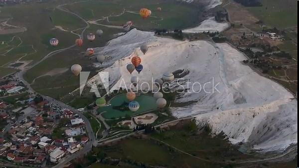 Hot air balloons and Natural travertine pools at sunrise in Pamukkale,